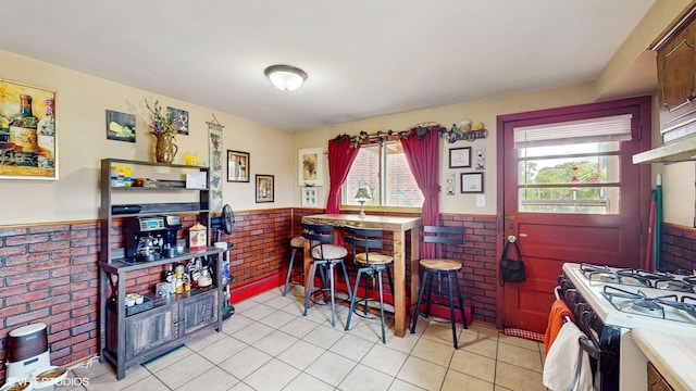 8824 Cherry Ave, River Grove, IL 60171 - dining space with a wainscoted wall, plenty of natural light, light tile patterned floors, and brick wall