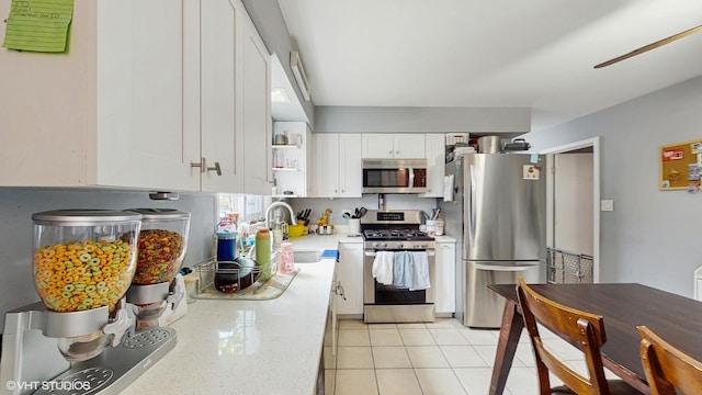 8824 Cherry Ave, River Grove, IL 60171 - kitchen with stainless steel appliances, white cabinetry, light stone countertops, a ceiling fan, and light tile patterned floors