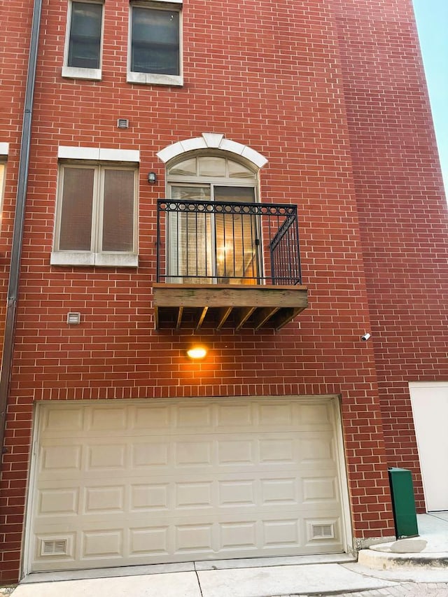 331 E 17th St, Chicago, IL 60616 - back of house with a balcony, a garage, brick siding, and driveway