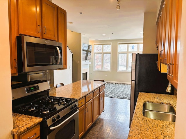 331 E 17th St, Chicago, IL 60616 - kitchen featuring stainless steel appliances, brown cabinets, dark wood-style flooring, light stone counters, and recessed lighting