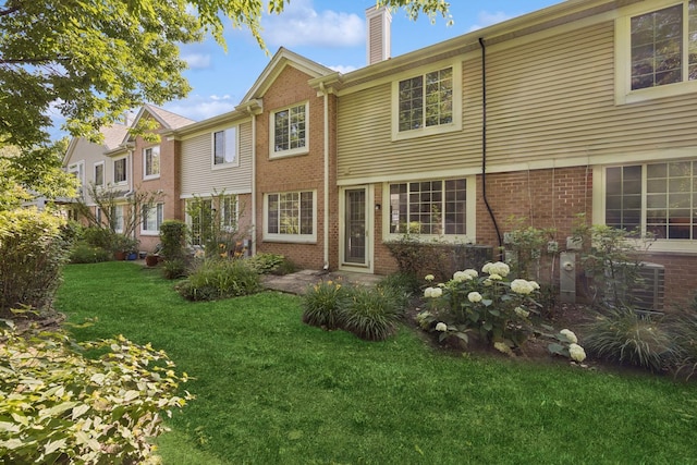 2566 Camberley Cir, Westchester, IL 60154 - view of front of home featuring brick siding, a chimney, and a front lawn