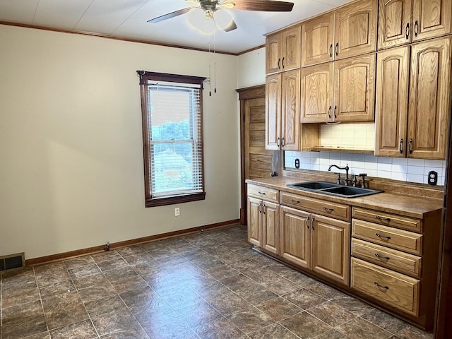 109 E Minnesota St, Spring Valley, IL 61362 - kitchen with a ceiling fan, backsplash, crown molding, brown cabinetry, and dark stone finish flooring