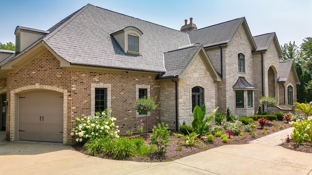 6403 S Garfield Ave, Burr Ridge, IL 60527 - french provincial home featuring an attached garage, driveway, stone siding, a chimney, and brick siding