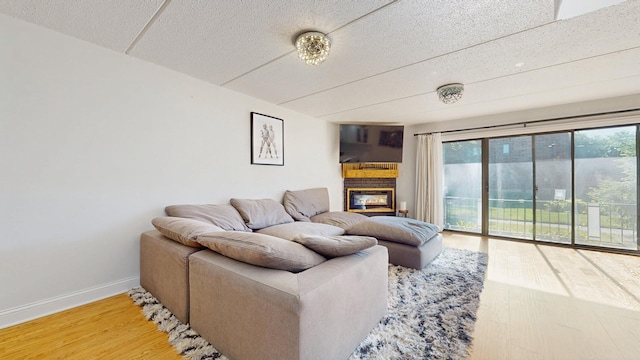 11104 O Gorman Dr Unit 41B, Palos Hills, IL 60465 - living area featuring healthy amount of natural light, wood finished floors, a glass covered fireplace, and a textured ceiling