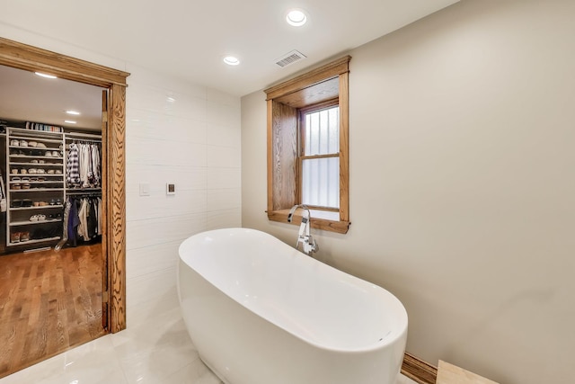 2333 N Spaulding Ave, Chicago, IL 60647 - bathroom featuring a freestanding tub, recessed lighting, a walk in closet, and tile walls