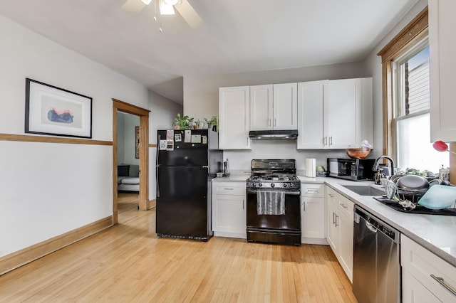 2333 N Spaulding Ave, Chicago, IL 60647 - kitchen with black appliances, under cabinet range hood, light countertops, and white cabinetry