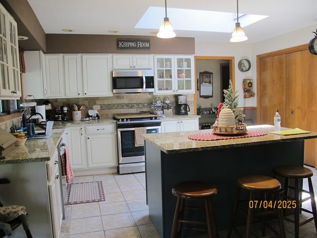 15521 116th Ct, Orland Park, IL 60467 - kitchen with stainless steel appliances, a skylight, a kitchen breakfast bar, and a kitchen island