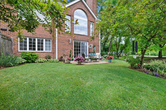700 Monroe Dr, Lindenhurst, IL 60046 - rear view of house with a patio area, brick siding, a lawn, and a chimney