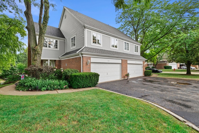 700 Monroe Dr, Lindenhurst, IL 60046 - view of front facade with an attached garage, brick siding, driveway, and a front yard