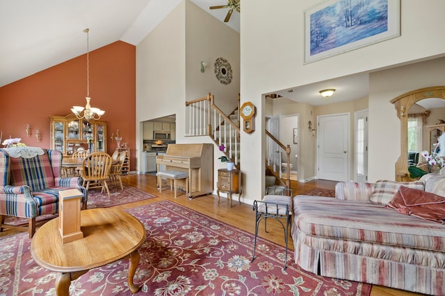 700 Monroe Dr, Lindenhurst, IL 60046 - living room featuring high vaulted ceiling, stairs, wood finished floors, a chandelier, and a ceiling fan