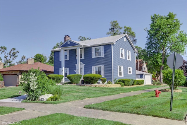 25 E 150th St, Harvey, IL 60426 - neoclassical / greek revival house featuring a chimney, a detached garage, and a front yard