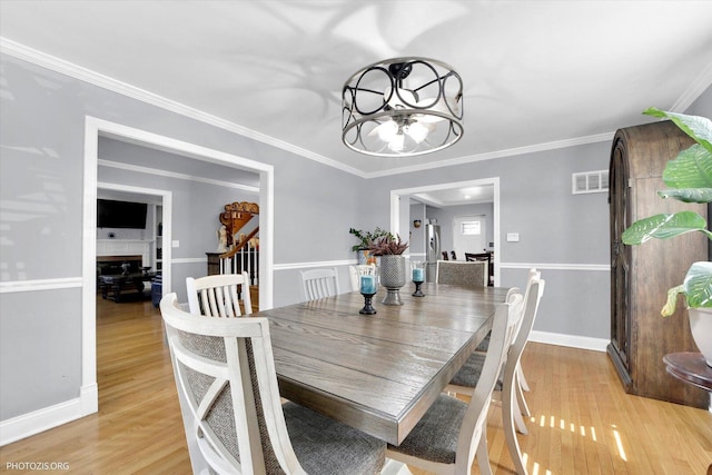 25 E 150th St, Harvey, IL 60426 - dining space featuring light wood-style flooring, crown molding, and a chandelier