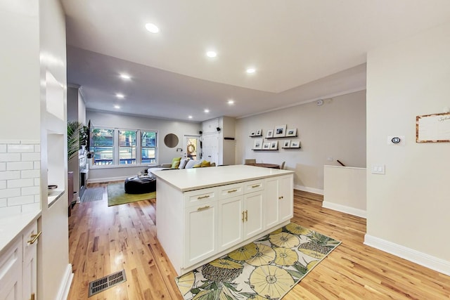 2136 W Schiller St Unit 1R, Chicago, IL 60622 - kitchen with light wood-type flooring, open floor plan, white cabinets, light countertops, and a center island