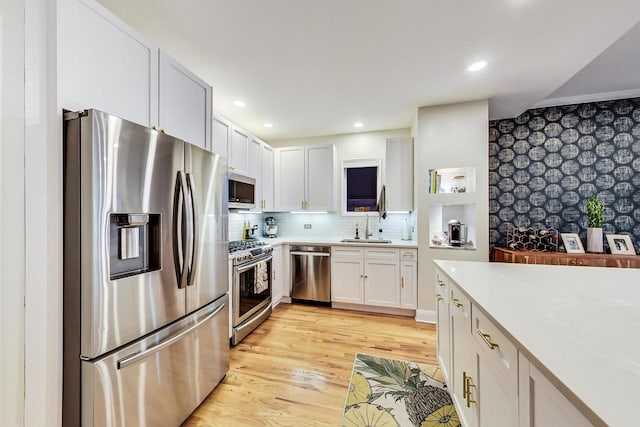 2136 W Schiller St Unit 1R, Chicago, IL 60622 - kitchen with appliances with stainless steel finishes, light countertops, light wood-type flooring, decorative backsplash, and white cabinets