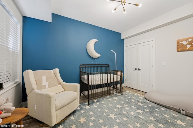 1018 N Larrabee St Unit 5S, Chicago, IL 60610 - bedroom with a chandelier, a nursery area, wood finished floors, and a closet