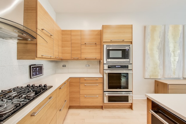 922 N Hermitage Ave Unit 1, Chicago, IL 60622 - kitchen with appliances with stainless steel finishes, wall chimney exhaust hood, light countertops, and tasteful backsplash