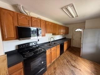 574 Isa Dr, Wheeling, IL 60090 - kitchen featuring black appliances, wood finished floors, brown cabinetry, and dark countertops