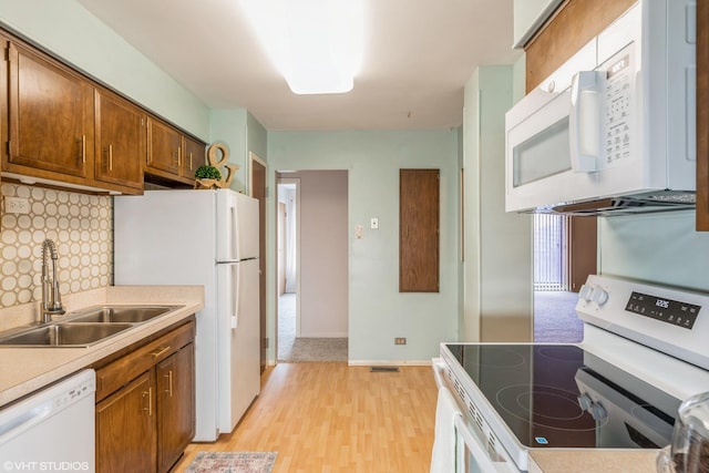 900 W Sunset Dr Unit 405, Glenwood, IL 60425 - kitchen with white appliances, light wood finished floors, tasteful backsplash, brown cabinets, and light countertops