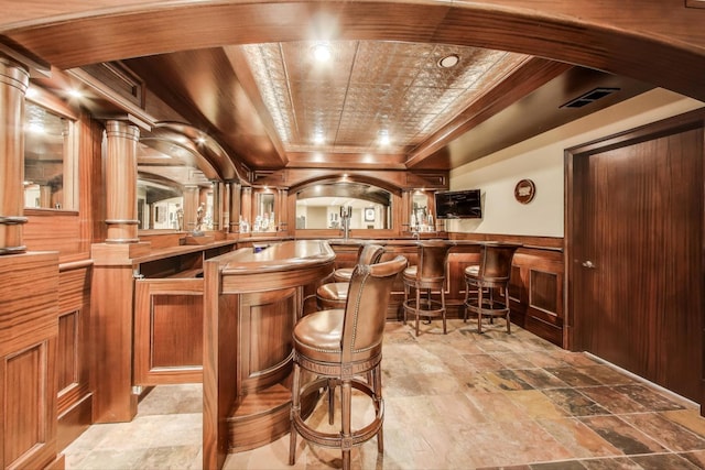 6067 N Oconto Ave, Chicago, IL 60631 - community bar area with light stone finish floors, a wainscoted wall, and arched walkways