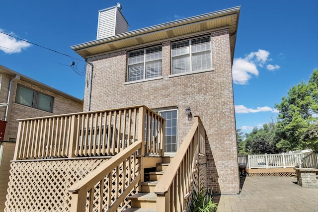6067 N Oconto Ave, Chicago, IL 60631 - back of property with brick siding, a chimney, a wooden deck, stairs, and a patio area