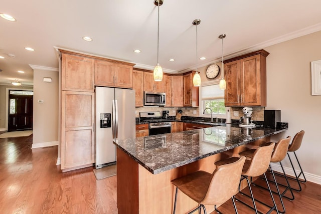 6067 N Oconto Ave, Chicago, IL 60631 - kitchen with appliances with stainless steel finishes, crown molding, a peninsula, tasteful backsplash, and pendant lighting