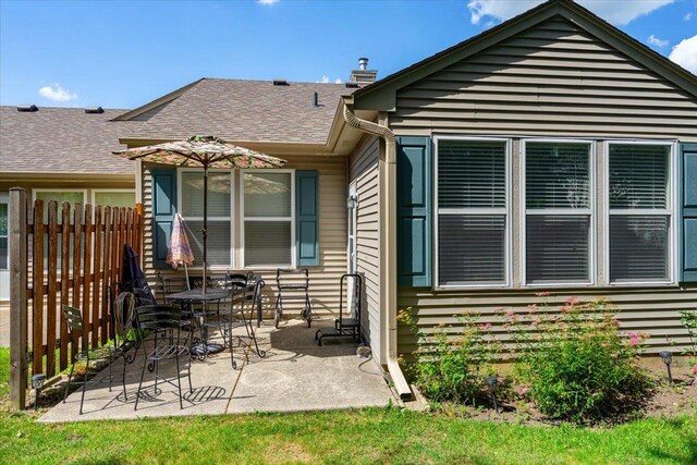 93 W Essington Dr Unit 93, Round Lake, IL 60073 - back of property with a patio, a shingled roof, and a chimney
