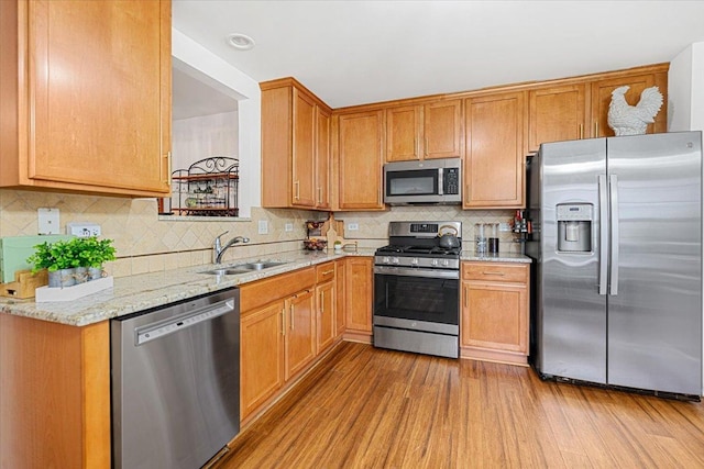 93 W Essington Dr Unit 93, Round Lake, IL 60073 - kitchen featuring stainless steel appliances, decorative backsplash, light stone countertops, wood finished floors, and brown cabinetry
