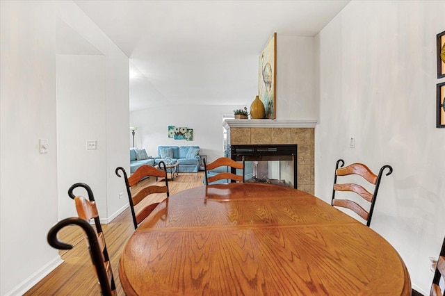 93 W Essington Dr Unit 93, Round Lake, IL 60073 - dining space with wood finished floors, a tiled fireplace, and vaulted ceiling