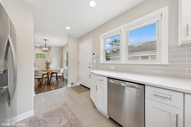 588 Glendale Ave, Glen Ellyn, IL 60137 - kitchen featuring appliances with stainless steel finishes, white cabinetry, recessed lighting, decorative backsplash, and a chandelier