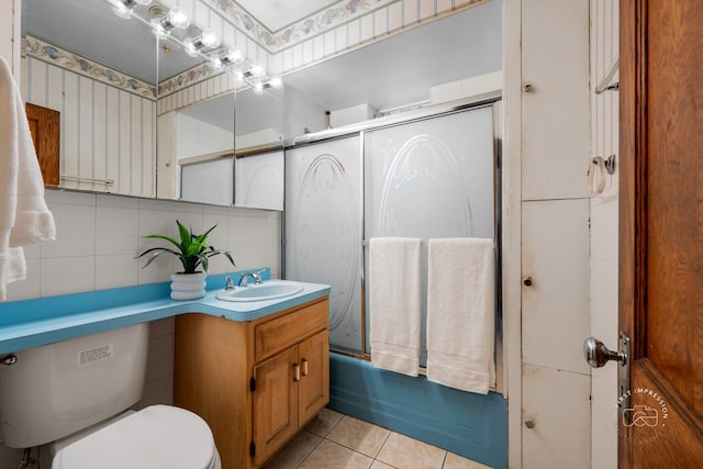 1246 N Monitor Ave, Chicago, IL 60651 - bathroom featuring vanity, tile walls, tile patterned flooring, and shower / bath combination with glass door