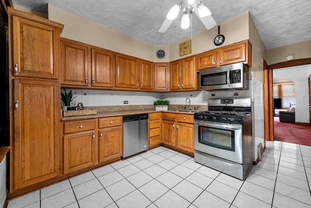 1246 N Monitor Ave, Chicago, IL 60651 - kitchen with appliances with stainless steel finishes, brown cabinets, and tasteful backsplash
