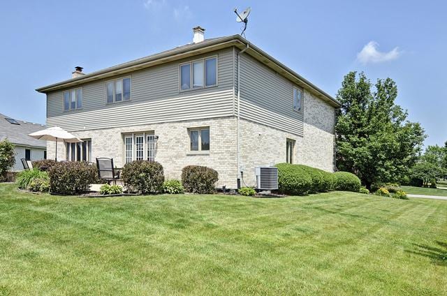 2301 Kerry Ln, Darien, IL 60561 - view of home's exterior with a chimney, a yard, and brick siding