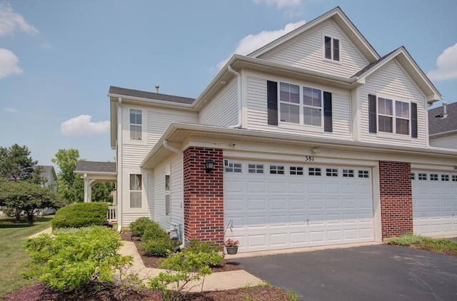 381 Chesapeake Ln, Oswego, IL 60543 - traditional-style house featuring brick siding, asphalt driveway, and a garage