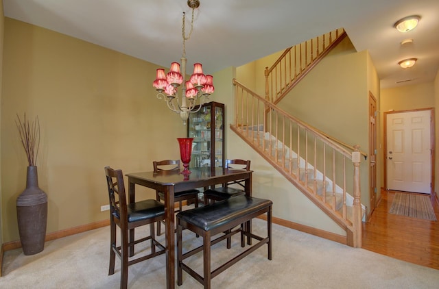 381 Chesapeake Ln, Oswego, IL 60543 - dining room with stairs, light colored carpet, and a chandelier
