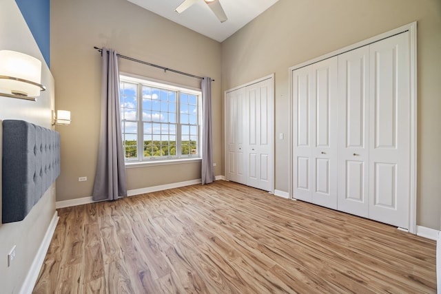 50 N Plum Grove Rd Unit 703E, Palatine, IL 60067 - unfurnished bedroom with two closets, wood finished floors, and a ceiling fan
