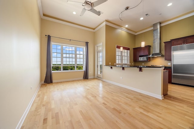 50 N Plum Grove Rd Unit 703E, Palatine, IL 60067 - kitchen with built in refrigerator, wall chimney exhaust hood, dark countertops, crown molding, and a breakfast bar area