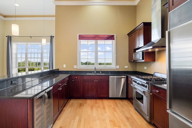 50 N Plum Grove Rd Unit 703E, Palatine, IL 60067 - kitchen featuring high end appliances, wall chimney range hood, ornamental molding, light wood-style flooring, and dark stone counters