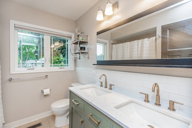 7613 Stratford Pl, Darien, IL 60561 - bathroom featuring healthy amount of natural light, double vanity, tasteful backsplash, and tile patterned floors