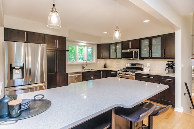 7613 Stratford Pl, Darien, IL 60561 - kitchen with appliances with stainless steel finishes, glass insert cabinets, hanging light fixtures, dark brown cabinetry, and recessed lighting