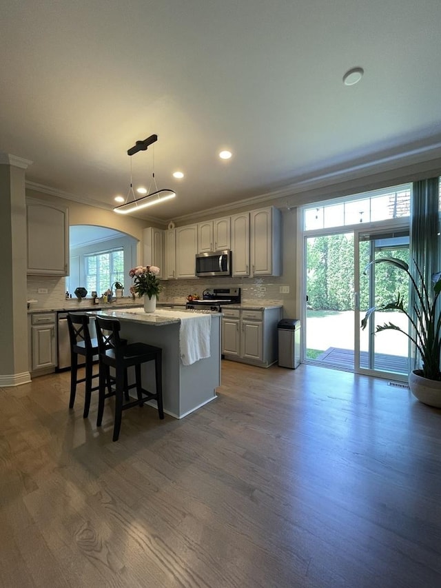 412 Merry Oaks Rd, Streamwood, IL 60107 - kitchen with appliances with stainless steel finishes, ornamental molding, decorative backsplash, recessed lighting, and a center island