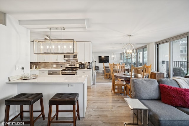400 E Randolph St Unit 826, Chicago, IL 60601 - kitchen featuring stainless steel appliances, light wood-style floors, white cabinetry, and tasteful backsplash