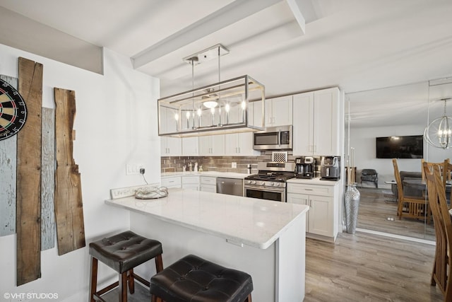 400 E Randolph St Unit 826, Chicago, IL 60601 - kitchen featuring stainless steel appliances, a chandelier, white cabinetry, and decorative backsplash