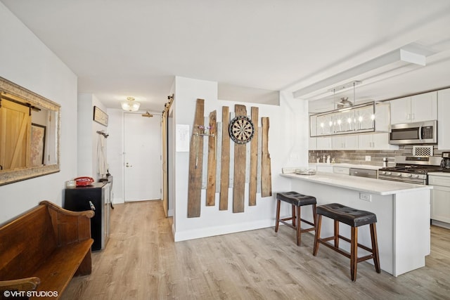 400 E Randolph St Unit 826, Chicago, IL 60601 - kitchen with stainless steel appliances, tasteful backsplash, a kitchen breakfast bar, and light wood-style flooring