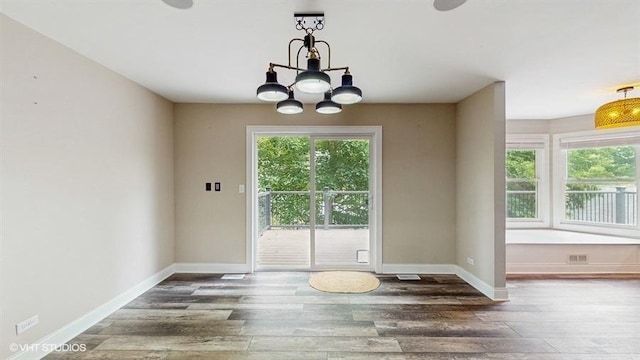 137 Forest Ave, Fox Lake, IL 60020 - unfurnished dining area with wood finished floors and a chandelier