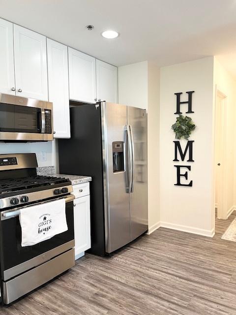 7031 Country Club Hills Dr, Fox Lake, IL 60020 - kitchen featuring appliances with stainless steel finishes, light wood-style floors, white cabinets, recessed lighting, and light countertops
