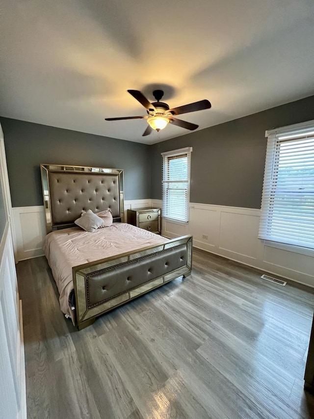 2472 Worthington Dr, Aurora, IL 60506 - bedroom featuring wainscoting, wood finished floors, ceiling fan, and a decorative wall
