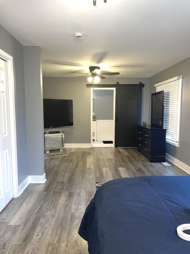 2472 Worthington Dr, Aurora, IL 60506 - unfurnished bedroom with a barn door, wood finished floors, and ceiling fan
