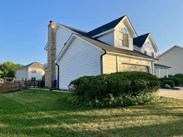 2472 Worthington Dr, Aurora, IL 60506 - view of side of property with board and batten siding, a chimney, an attached garage, and concrete driveway