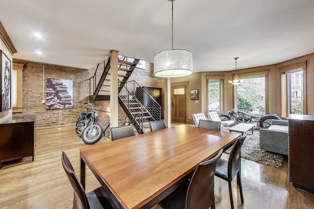 3822 N Claremont Ave, Chicago, IL 60618 - dining area featuring brick wall, wood finished floors, and stairs