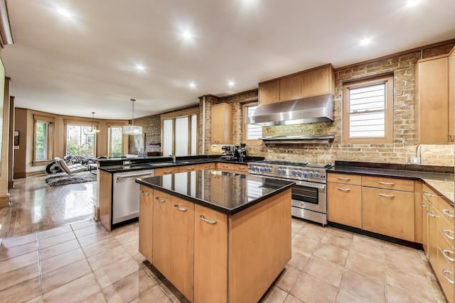 3822 N Claremont Ave, Chicago, IL 60618 - kitchen with wall chimney range hood, stainless steel appliances, a peninsula, healthy amount of natural light, and recessed lighting